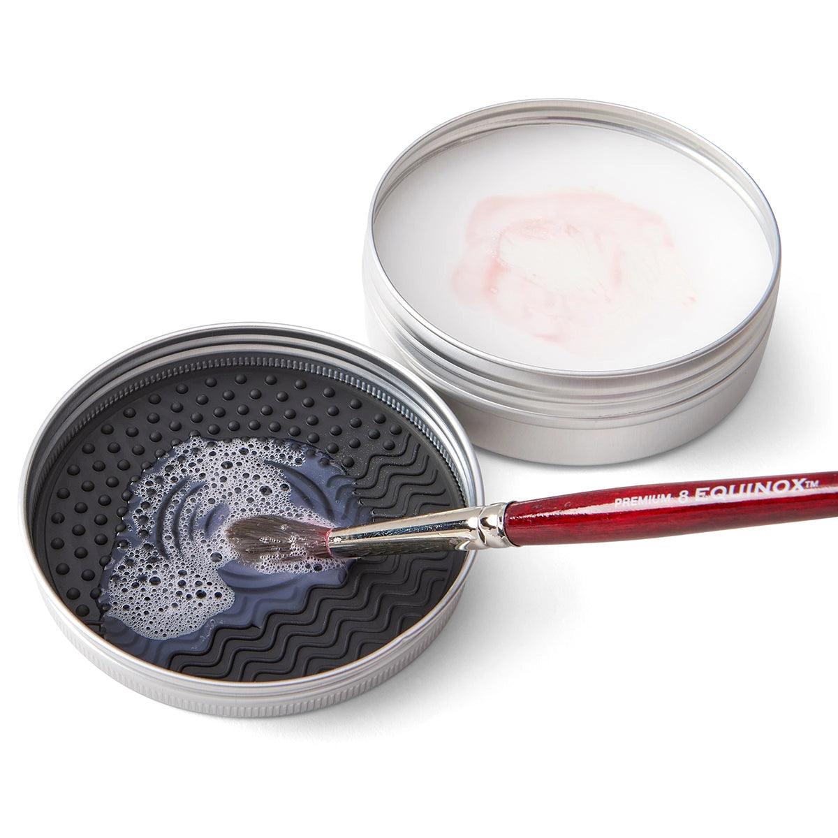 Two tins of brush soap, one open with a brush inside, on a white background